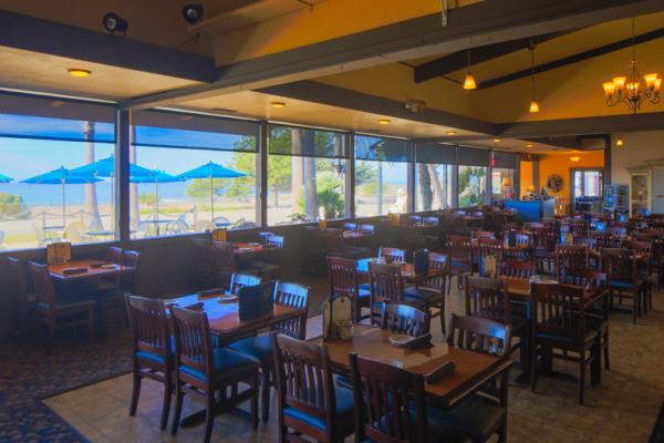 tables and chairs inside restaurant with ocean view